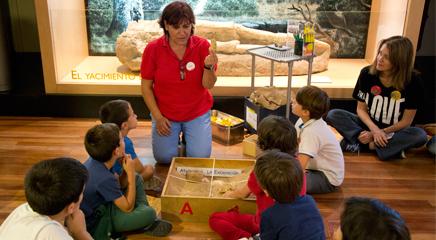 Una educadora del museo realizando una actividad sobre fósiles